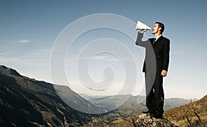 Businessman Shouting on the Top of the Mountain