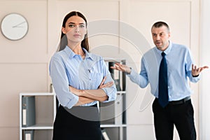 Businessman Shouting At Woman Employee Standing In Modern Office