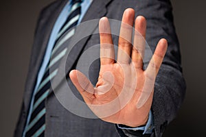 Businessman show hand sign for stop and holding, Concept of professional warning for stop new investment in world crisis