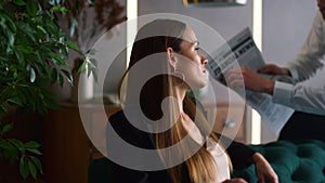 Businessman showing article in financial newspaper to businesswoman in office