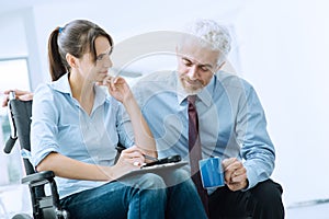 Businessman showing a document to a woman in wheelchair