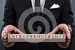 Businessman showing entrepreneurship blocks