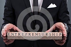 Businessman showing entrepreneurship blocks photo
