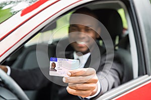 Businessman Showing His Driving License From Open Car Window