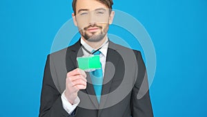 Businessman showing his id on blue