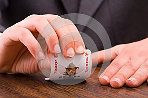 Businessman showing joker card.