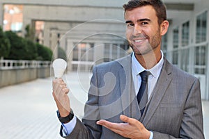 Businessman showing light bulb in office building