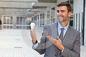 Businessman showing light bulb in office building