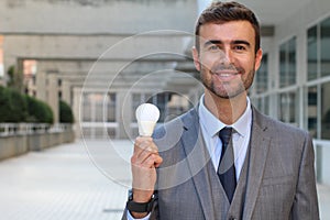 Businessman showing light bulb in office building