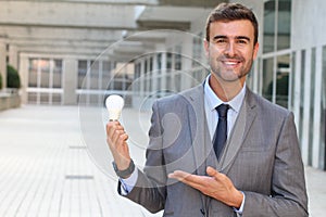 Businessman showing light bulb in office building