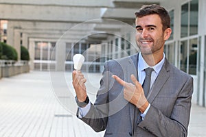 Businessman showing light bulb in office building