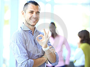 Businessman showing OK sign with his thumb up.