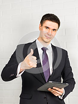 Businessman showing OK sign with his thumb up.