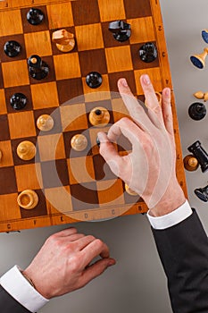 Businessman showing ok sign while playing chess.