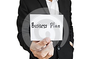 Businessman showing paper note with the word Business Plan, isolated on white background