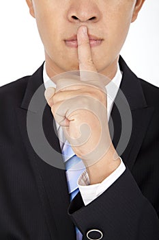 Businessman showing quiet gesture