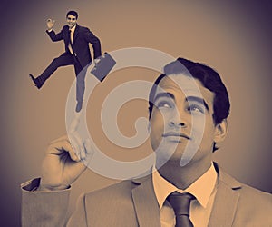 Businessman showing shrunk colleague posing on his finger