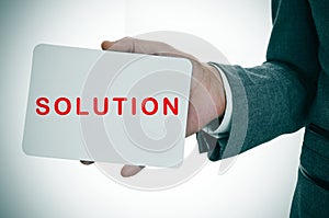 Businessman showing a signboard with the word solution