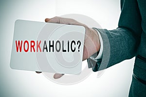 Businessman showing a signboard with the word workaholic photo