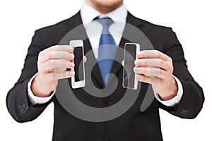 Businessman showing smartphones with blank screens
