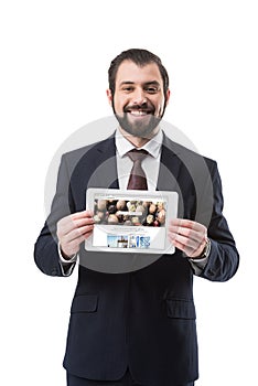 smiling businessman showing digital tablet with depositphotos website