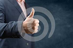 Businessman showing thumbs up - closeup shot. Businessman with thumb up gesture on blue background. Business concept