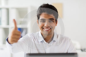 Businessman showing thumbs up at office