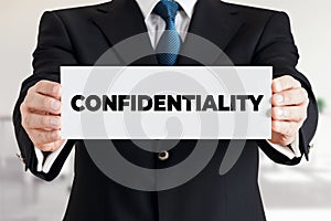 Businessman shows a banner with the word confidentiality. Business data or information secrecy protection