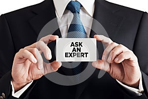 Businessman shows business card with the message ask an expert. Professional counseling, support or solution