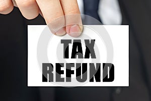 Businessman shows a card with the text - TAX REFUND