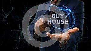 Businessman shows concept hologram Buy house on his hand