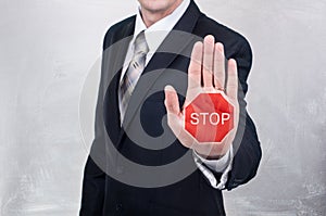 Businessman shows stop sign painted on the hand