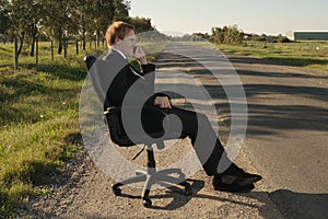 Businessman on the side road in chair