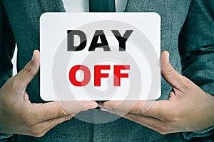 Businessman with a signboard with the text day off