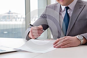 The businessman signing business documents in office