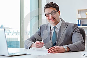 The businessman signing business documents in office