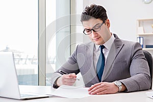 The businessman signing business documents in office
