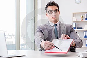 The businessman signing business documents in office