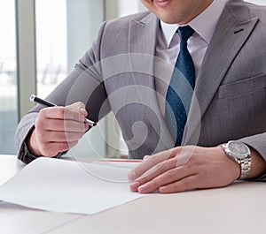 Businessman signing business documents in office