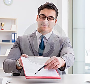 Businessman signing business documents in office