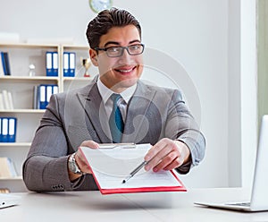 Businessman signing business documents in office