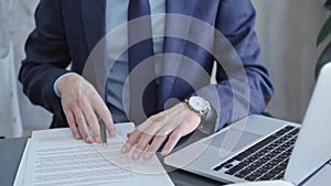 Businessman signing contract at desk. Close-up of a male executive's hands signing a legal document in a modern