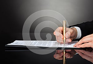 Businessman signing document at desk photo