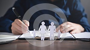 Businessman signing in document. Paper cut family on the desk. Family, Life, Health insurance