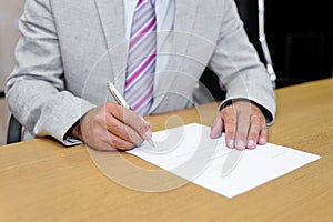 Businessman signing a paper form