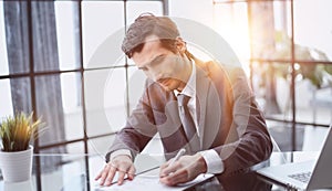 businessman signs a contract at the table in the office close-up.