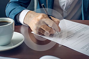 Businessman signs important legal documents on the desktop with Cup of coffee