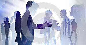Businessman silhouette in formal suit holds out his hand for a handshake. Corporate culture concept. collegues are on background. photo