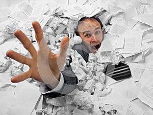 Businessman sinking in heap of documents