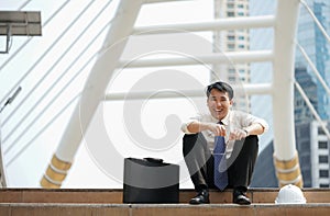 Businessman sit happily laughing at the ladder modern walkway